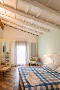 um quarto com uma cama grande e um cobertor azul e branco em La Meridiana B&B em Casale sul Sile