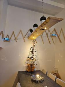 Loft 6 couchages (4+2) في كوتيريه: غرفة طعام مع طاولة مع شجرة عيد الميلاد