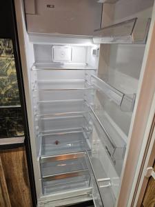 an empty refrigerator with its door open and its shelves at Loft 6 couchages (4+2) in Cauterets