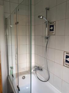 a shower with a glass door next to a bath tub at Grüne Oase in Bad Nenndorf +29 photos
