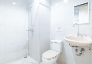 a white bathroom with a toilet and a sink at RedDoorz at Crowne One Condo in Manila
