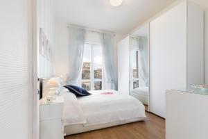 a white bedroom with a bed and a window at Stellamaris, Stile Marino e Relax a Viareggio in Viareggio