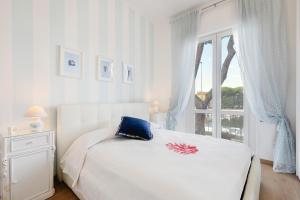 una camera bianca con un letto e una finestra di Stellamaris, Stile Marino e Relax a Viareggio a Viareggio