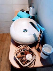 a bathroom with a white sink and a basket of food at B&B La Genzianella in Perarolo di Cadore