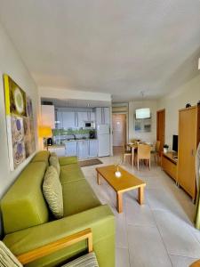 ベナルマデナにあるBENALBEACH apartamento frontal mar 1 dormitorio 6ªのリビングルーム(緑のソファ、テーブル付)