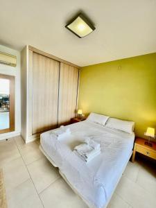 ベナルマデナにあるFrontal Sea View Apartment Benalbeachのベッドルーム1室(黄色い壁の大きな白いベッド1台付)