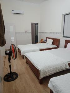 een kamer met drie bedden en een camera erin bij Tam Ky XO Hotel in Tam Ky