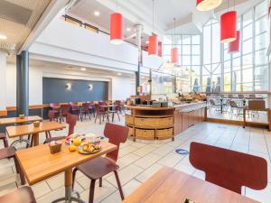 una sala da pranzo con tavoli e sedie e una caffetteria di B&B HOTEL Lyon Eurexpo Bron a Bron