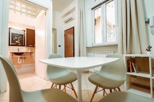 a dining room with a white table and chairs at Loft Pozzo Strada in Turin