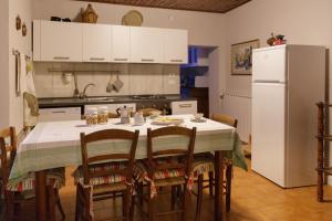 kuchnia ze stołem z krzesłami i lodówką w obiekcie Casa Pini Rio_A w mieście Riolunato