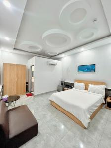 - une chambre avec un grand lit et un canapé dans l'établissement Khách sạn Khang Điền 2, à Xóm Phước Mỹ