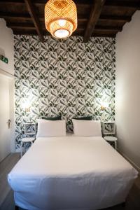 ein Schlafzimmer mit einem weißen Bett und einer Wand in der Unterkunft Hotel Nella in Florenz