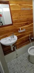 a bathroom with a sink and a toilet at Pondok Jati Mulo Jembrana in Jembrana