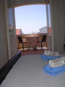 a bedroom with a bed and a table and chairs at Guesthouse Goga in Rab