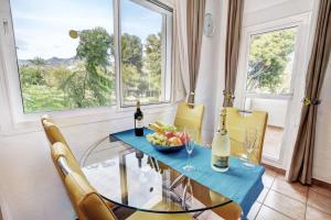 - une salle à manger avec une table en verre et un bol de fruits dans l'établissement Luxury Apartment in BenalBeach with Water Park, à Benalmadena Costa