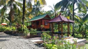 a small house with a gazebo in a garden at Pondok Jati Mulo Jembrana in Jembrana