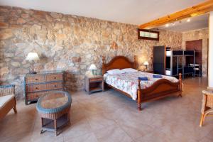 1 dormitorio con cama y pared de piedra en Aaccent Montblanc - Prenafeta, en Montblanc