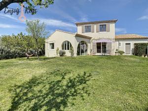 una casa con un gran césped delante de ella en Magnifique Villa Provençale en Mallemort