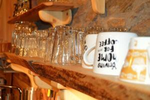 um balcão com vasos de vidro e copos sobre ele em EskiZ - Our stone home em Chepelare
