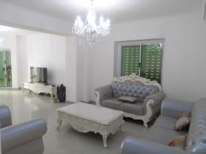 soggiorno con divani e lampadario pendente di Residencial beira mar Benguela a Benguela