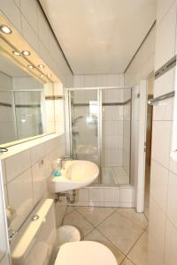 een badkamer met een toilet, een wastafel en een douche bij Schwalbe - Tripp in Westerland