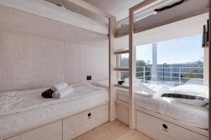 a bedroom with two bunk beds and a window at Pupsi Garden Villa in Drage