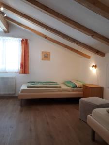 een slaapkamer met een bed in een kamer met houten vloeren bij Ferienwohnung Tschudiboden in Flumserberg