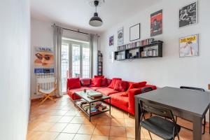 un soggiorno con un divano rosso e un tavolo di Casa Giancarlo by Rentbeat a Roma