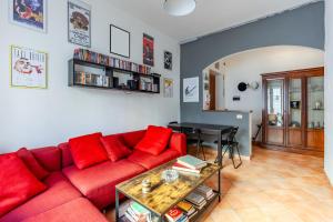 un soggiorno con un divano rosso e un tavolo di Casa Giancarlo by Rentbeat a Roma