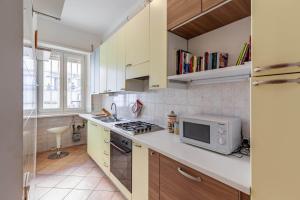 una cucina con forno a microonde e fornello forno superiore di Casa Giancarlo by Rentbeat a Roma Altre 16 foto
