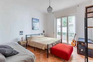 una camera con due letti e uno sgabello rosso di Casa Giancarlo by Rentbeat a Roma