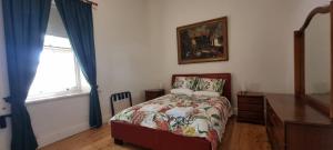 a bedroom with a bed and a dresser and a window at The Sunday School Cottage on the Heysen Trail in Burra