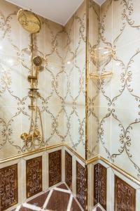 a bathroom with a gold wall with a shower at Manor Luxury Hotel Baku in Baku