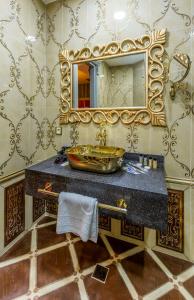 a bathroom with a sink and a mirror at Manor Luxury Hotel Baku in Baku