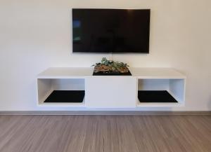 a white entertainment center with a flat screen tv on a wall at Ferienwohnung "Urlaub bei Lina" in Hergatz