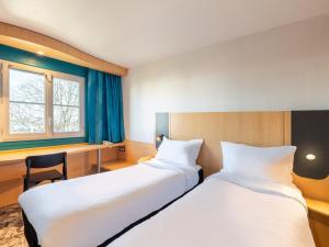 Un pat sau paturi într-o cameră la B&B HOTEL Lyon Eurexpo Bron