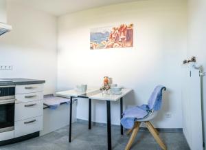 a small kitchen with a table and a chair at Ferienwohnung "Urlaub bei Lina" in Hergatz