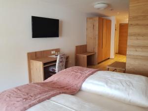 Schlafzimmer mit einem Bett und einem Flachbild-TV in der Unterkunft Hotel Restaurant Schaurhof in Sterzing