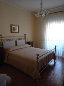 - une chambre avec un lit et une fenêtre ornée d'un lustre dans l'établissement Melinda House, à Cefalù