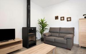 ein Wohnzimmer mit einem Sofa und einem TV in der Unterkunft Villa Montenmedio Paula in El Soto