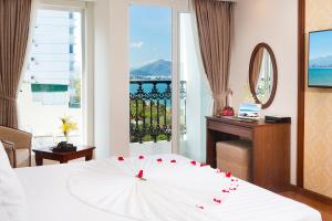 a bedroom with a white bed with a white umbrella at Regalia Nha Trang in Nha Trang