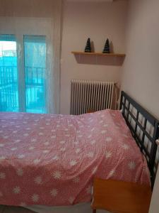 um quarto com uma cama com um edredão vermelho em Dimitris em Trikala