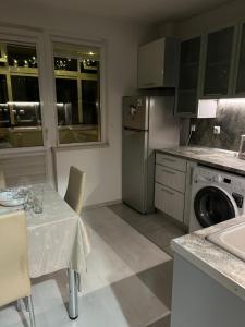 una pequeña cocina con mesa y lavavajillas en Apartament Kamarashki, en Troyan