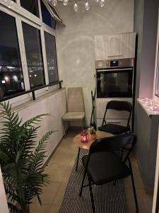 sala de estar con mesa, sillas y ventanas en Apartament Kamarashki, en Troyan