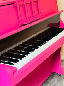 Magenta Melodies, 5 Bedroom House في بلاكبول: بيانو وردي مع لوحة مفاتيح سوداء وبيضاء