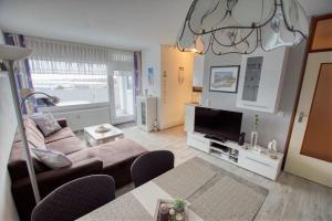 sala de estar con sofá y TV en Ferienpark - Haus F, App 0F0508, en Heiligenhafen