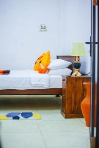 a bedroom with a bed and a table with a lamp at The Glade in Weligama