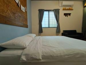 a bedroom with a white bed and a window at 肆拾光陰 寵物友善 老宅民宿 Forty Time Homestay in Longjing