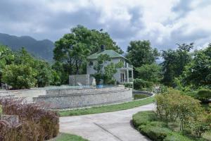 a house on a hill with a stone wall at The Corbett Greens in Rāmnagar