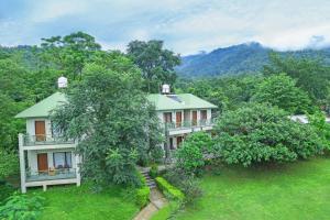 a large house with trees in front of it at The Corbett Greens in Rāmnagar